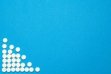 group of round white pills on blue background