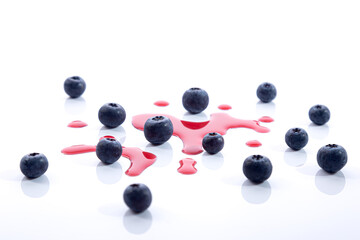Blueberries with juice drops on white background.