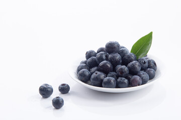 Dish with a bunch of blueberries isolated on  white background.