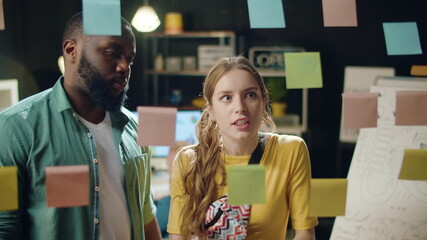 Closeup annoyed businesswoman putting sticker on colleague forehead indoor
