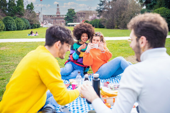 Four cheerful friends diverse multiethnic having fun doing pic nic