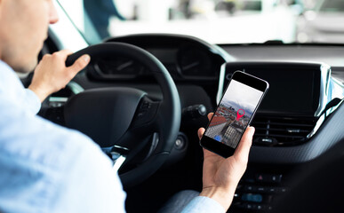 Man Driving Car Using Phone With Mobile Navigation Application