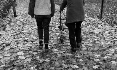 Elderly woman with walker taking a walk with granddaughter in winter