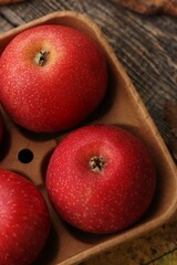 Juicy red apples and autumn leaves on the table