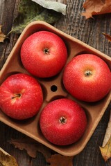 Juicy red apples and autumn leaves on the table