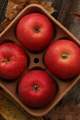 Juicy red apples and autumn leaves on the table
