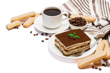 Traditional Italian Tiramisu dessert square portion on ceramic plate, savoiardi cookies and cup of fresh espresso coffee isolated on white