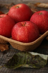 Juicy red apples and autumn leaves on the table