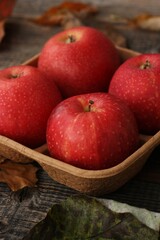 Juicy red apples and autumn leaves on the table
