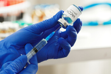 Doctor hands holding covid-19 vaccine preparing for vaccination of a patient