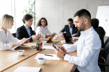 Businessman Using Tablet Computer At Corporate Meeting In Modern Office