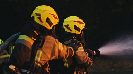 Fireman extinguish fire with the hose. Burning house fire drill. High quality photo