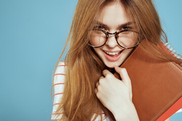 energetic female student with notepads and glasses model blue background
