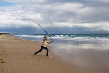 photograph of a fisherman on the beach