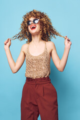 Pretty woman Curly hair fashionable clothes blue background lipstick 