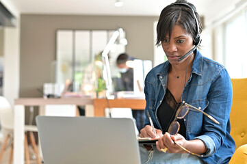 Businesswoman with headset working in open space coworking office