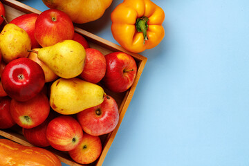 Pumpkins, apples and bell pepper composition on blue background