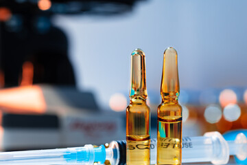 Vial of vaccine bottle with a syringe close up
