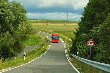 roter Linienbus im Herbst auf einer Landstrasse im Hunsrück
