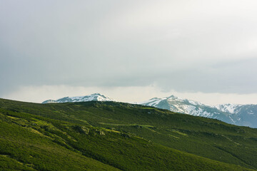 Fototapeta premium landscape with clouds snowy mountains ang green valley