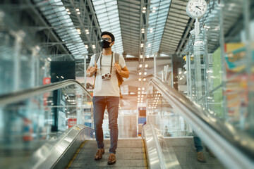New normal and social distancing concept.Traveler business man wearing face mask and waiting to board in to airplane at terminal airport for protection coronavirus(covid-19) during virus pandemic
