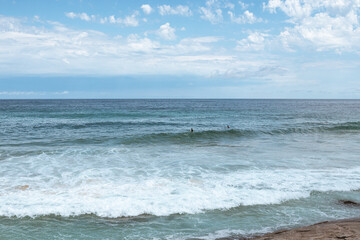 Surfers take on waves at the beach