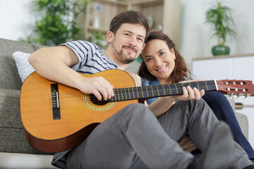 couple at home man playing guitar