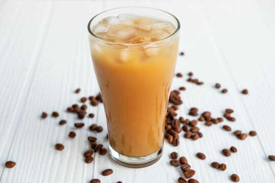 .Iced coffee in a glass On a white wooden background