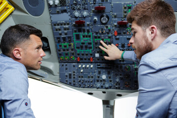 Fototapeta na wymiar two males in the cockpit discussing about the commands