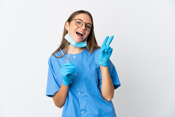 Lithuanian woman dentist holding tools over isolated background smiling and showing victory sign