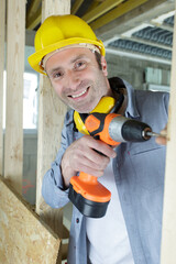 happy handyman drilling a wall