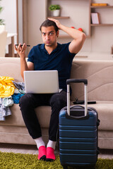 Young man preparing for journey at home