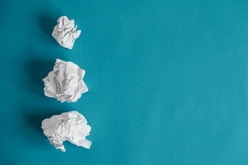 Crumpled paper balls on a blue background. Minimalist concept. Top view. Copy, empty space for text