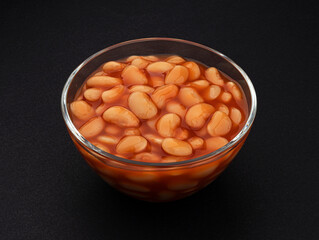 Baked beans in tomato sauce on black background