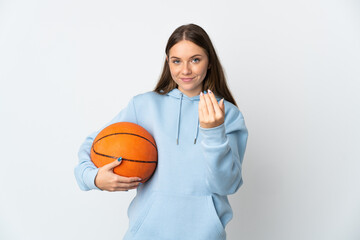 Young Lithuanian woman playing basketball isolated on white background inviting to come with hand. Happy that you came