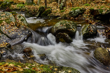 Fototapeta na wymiar Small waterfalls in the bed of the Sestil de Maíllo stream. Autumn in the Sierra de Guadarrama National Park. Madrid's community. Spain