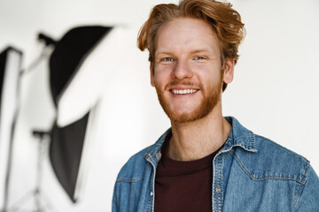 Happy handsome ginger guy smiling and looking at camera
