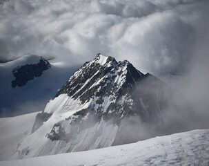 tall rugged mountain peak stand out of high clouds