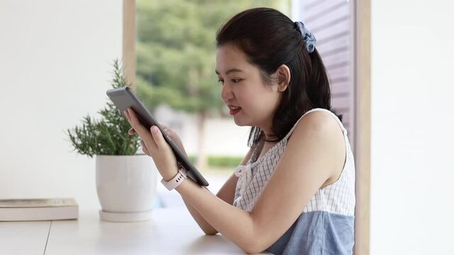 Young lady is happy to play the laptop enjoying surfing internet study work shopping online using social media apps or watch her favorite series in a quiet caf&eacute;, 4K footage.