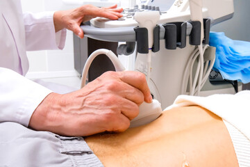 Adult doctor diagnoses human kidneys using ultrasound