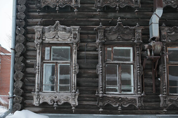 Ornamental windows with decorative carved frames on vintage wooden house on Karl Marx Street, 27/1,...