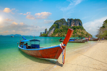 Thai traditional colorful wooden longtail boat and beautiful sand beach in Thailand.