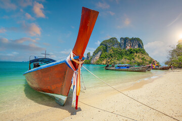 Thai traditional colorful wooden longtail boat and beautiful sand beach in Thailand.