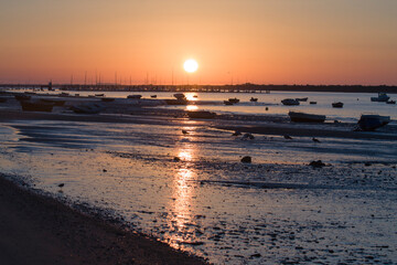 beautiful sunrise on a beach with boats