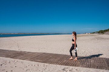 beautiful young girl with sunglasses walking on beach walkway