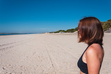 beautiful young girl looking at the horizon on the beach