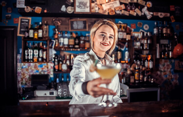 Girl bartender makes a cocktail in the pothouse