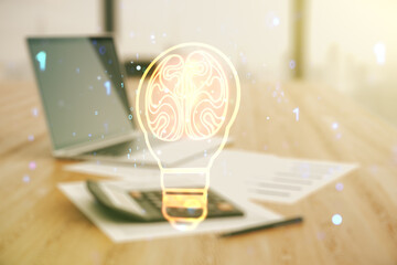 Abstract virtual light bulb illustration with human brain on blurry calculator and computer...