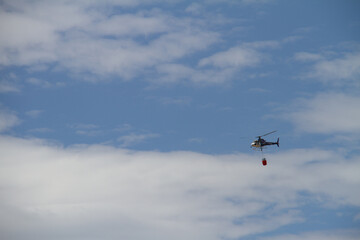 Helicóptero con carga de agua extinguiendo fuego