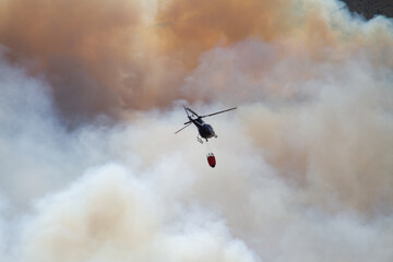 Helicóptero con carga de agua extinguiendo fuego